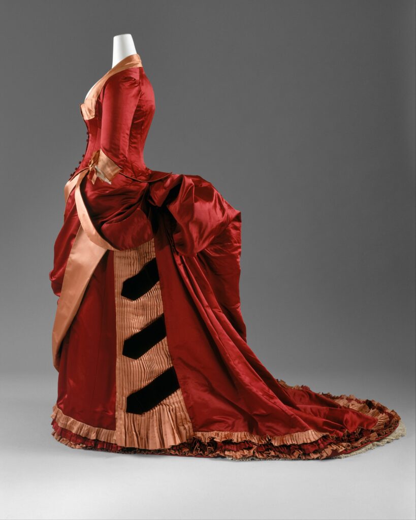 1880s second bustle era dress with exaggerated shelf-like back projection, high neckline, and gathering at shoulders for dating old family photographs - Family History Foundation